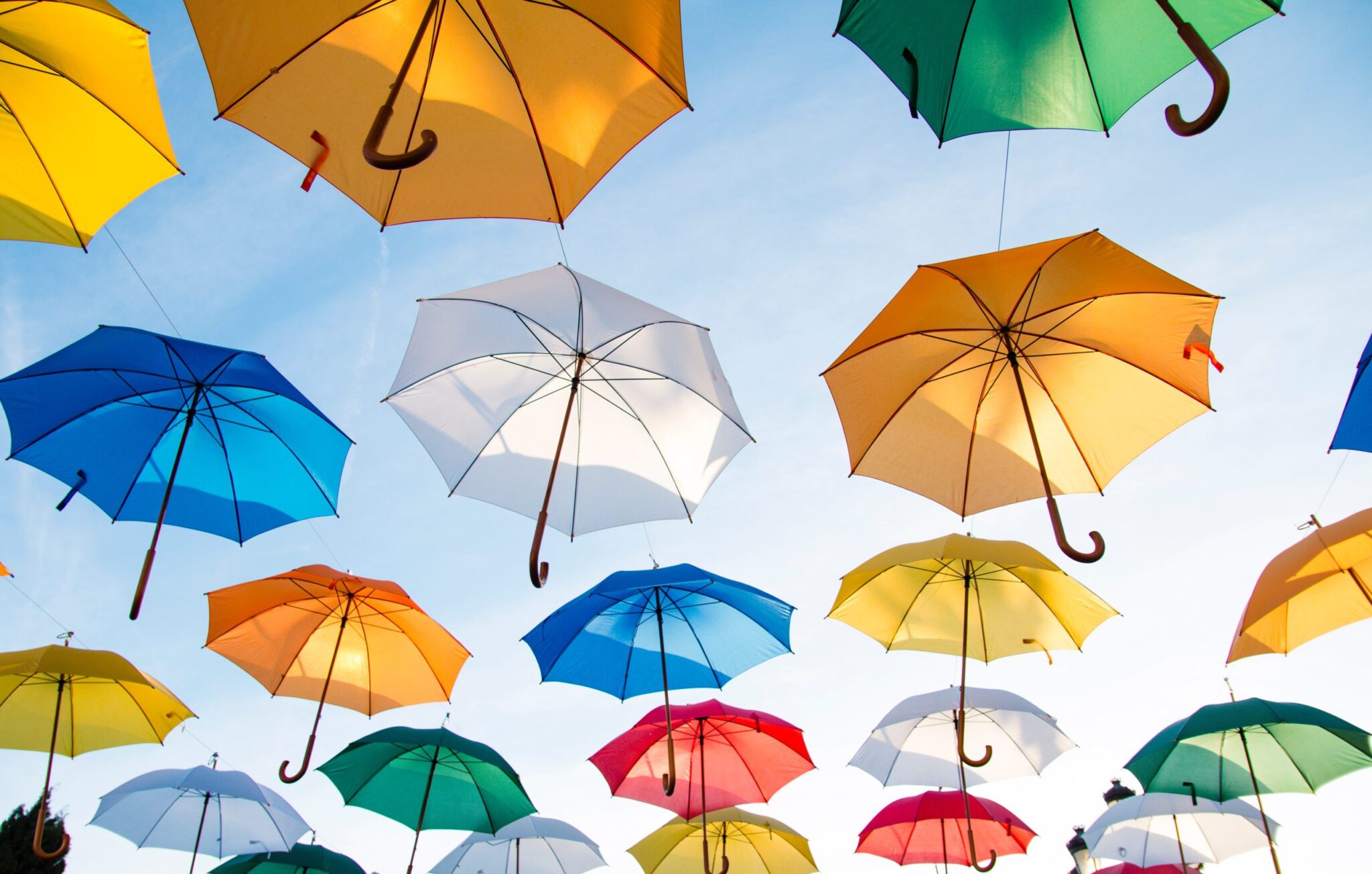 Vários guarda chuvas coloridos no céu